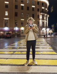 Lifestyle portrait of a teenage boy using a smartphone outdoors