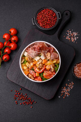 Appetizing salad with prosciutto, pumpkin, cheese and tomatoes