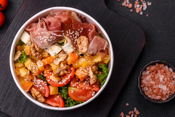 Appetizing salad with prosciutto, pumpkin, cheese and tomatoes