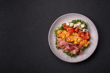 Appetizing salad with prosciutto, pumpkin, cheese and tomatoes