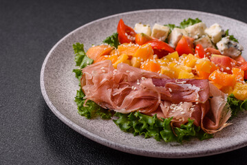 Appetizing salad with prosciutto, pumpkin, cheese and tomatoes
