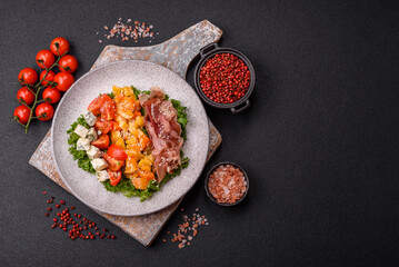 Appetizing salad with prosciutto, pumpkin, cheese and tomatoes