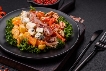 Appetizing salad with prosciutto, pumpkin, cheese and tomatoes