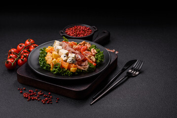 Appetizing salad with prosciutto, pumpkin, cheese and tomatoes
