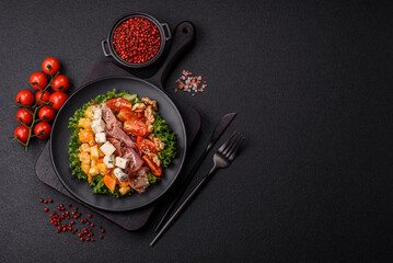 Appetizing salad with prosciutto, pumpkin, cheese and tomatoes