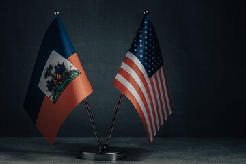 Table flags United States America and National Flag Haiti on dark background.