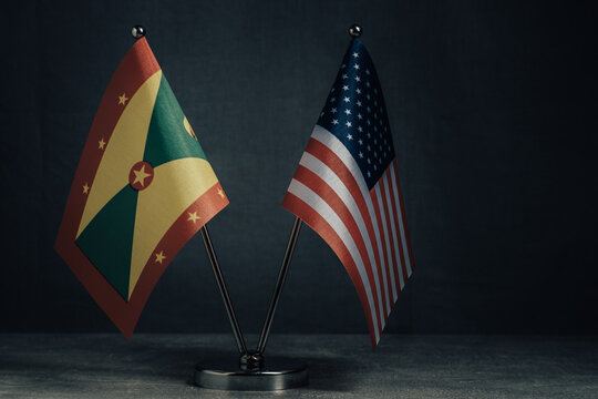 Table flags United States America and National Flag Grenada on dark background.