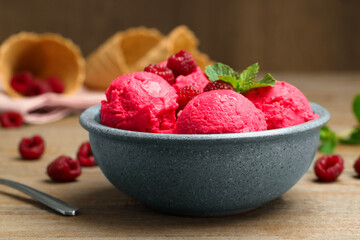 Delicious raspberry sorbet, fresh berries and mint in bowl on wooden table, closeup