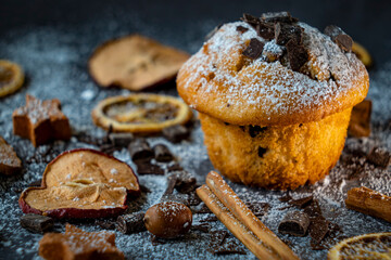 Muffins with chocolate chips and dried fruits on a black background