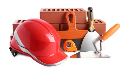 Fototapeta premium Orange hard hat, red bricks, trowel, measuring tape and putty knives isolated on white. Building material and construction tools