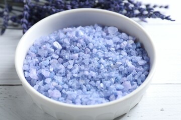 Natural sea salt and lavender flowers on white wooden table, closeup