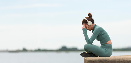 Sporty woman sitting with her head in her hands outdoors. sports emotion concept