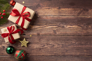 Fototapeta premium Beautifully wrapped Christmas gifts with red ribbons and ornaments placed on a rustic wooden table creating a festive holiday atmosphere