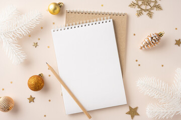 Top view of a blank notepad with pencil surrounded by golden Christmas ornaments and decorations,...