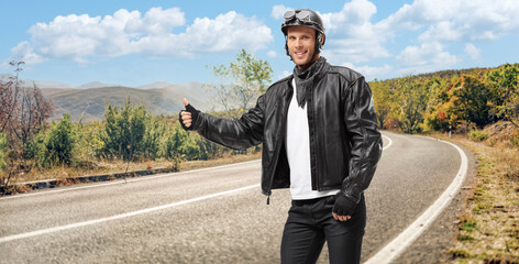 Biker hitchhiking on a road