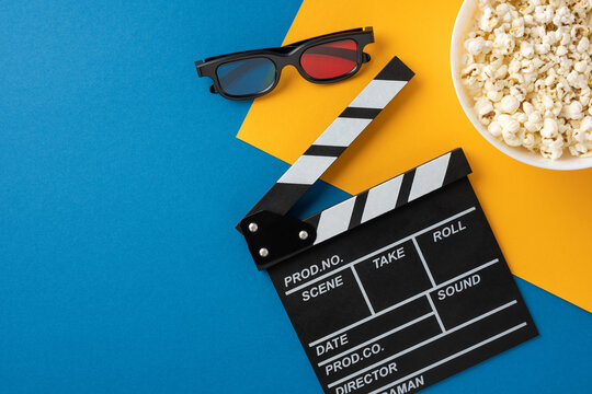 A flat lay of movie night essentials including a clapperboard, 3D glasses, and a bowl of popcorn captures the cinematic experience