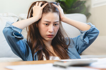 young asian woman cover her head after stressed with monthly bill expenses and credit card debt.