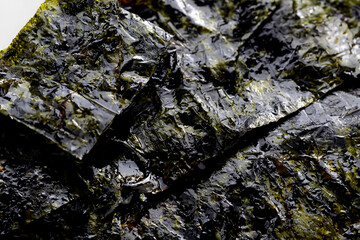 A close-up of a shiny, textured roasted seaweed sheet, ideal for backgrounds, textures, or culinary design elements.