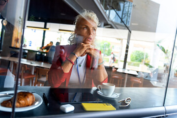 Elderly Russian businesswoman on a phone call with headset.