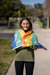 Lesbian girl wrapped in LGBT flag with happy expression