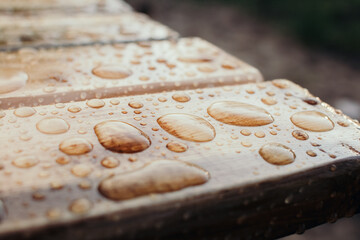 Water drops pattern on wooden material. Tinted colors. Shallow depth of field.