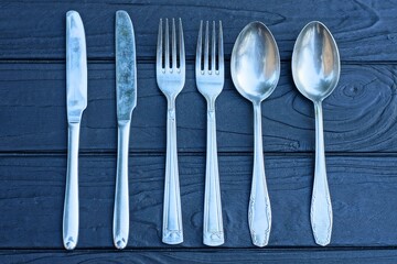 set of cutlery iron gray industrial shiny sharp kitchen clean old knives forks and spoons lie on...