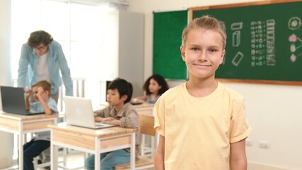 Caucasian cute student looking at camera while friend studying about writing engineering code or coding prompt. Professional smart teacher checking prompt while teaching about AI generated. Pedagogy.