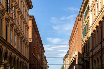 View of historic buildings in the city center, highlighting classical architecture against a clear blue sky, Bologna, Italy
