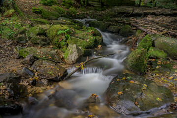 Langzeitbelichtung eines kleinen Wasserfalls im Wald