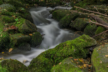 Obraz premium Langzeitbelichtung eines kleinen Wasserfalls im Wald