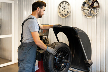 Mechanic operating tire changing machine for seasonal tire change