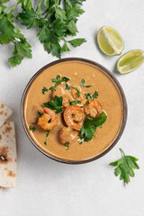 Curry shrimp in white bowl on light background with copy space top view. Asian food concept