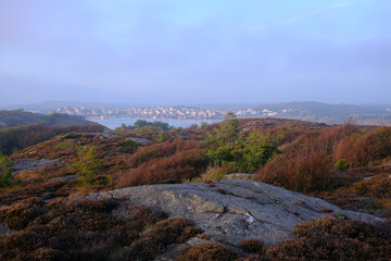 Stocken town at sunset with heather foreground, purple sky and fog, Orust, Sweden