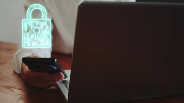 A businessman working on a laptop and with a smartphone demonstrates a hologram in the form of a lock symbolizing closed access. Cg