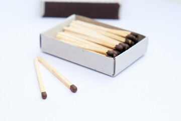 A box of matches with two matches left out of the box.