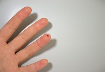 finger with blood for glycose blood test