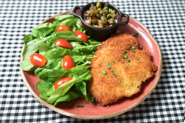 plate of food with chicken breast salad and caper sauce fish and chicken fillet