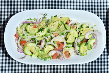 healthy food dish with salad greens vegetables seasoned salad vegan lunch tomato and onion green zucchini