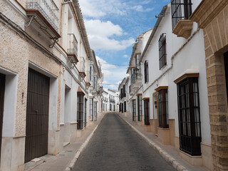 Typical Andalusian stately street in Osuna with white walls with its characteristic bars in Seville