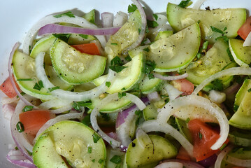 healthy food dish with salad greens vegetables seasoned salad vegan lunch tomato and onion green zucchini