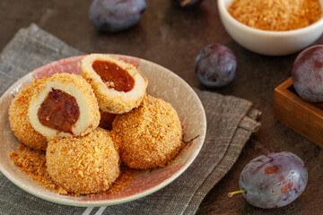 Traditional sweet steamed dumplings with a plum jam, sprinkled with sweet crumble and cinnamon on  plate