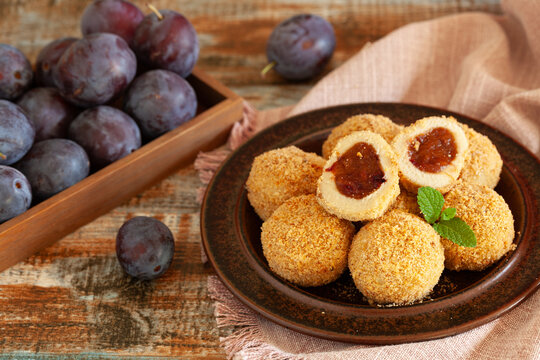 Traditional sweet steamed dumplings with a plum jam, sprinkled with sweet crumble and cinnamon on  plate