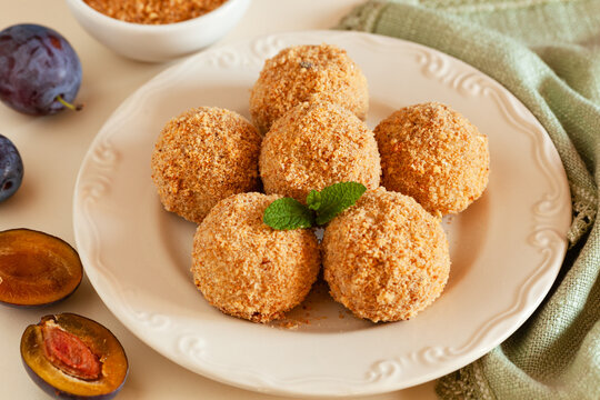 Traditional sweet steamed dumplings with a plum jam, sprinkled with sweet crumble and cinnamon on  plate