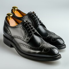Black leather brogue shoes with brown wooden shoe trees