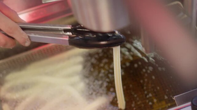 Churro Extraction through a big nozzle sink in hot oil