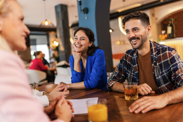 Friends hanging out at the cafe. They drink and talk.