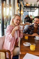 Young cheerful woman drinking hot drink in a restaurant.