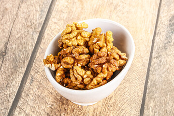 Cracked unshelled walnut in the bowl