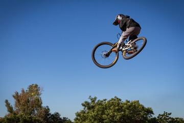 Mountain Biker Soaring Mid-Air, BMX Freestyle Jump, Extreme Sports, Outdoor Adventure, Adrenaline...