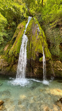Waterfall flows down the side of a moss covered mountain, waterfall on a moss covered mountain